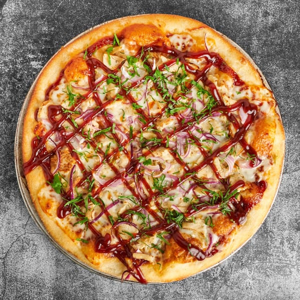Trent's Pizzeria BBQ chicken pizza with red onions, cilantro, and a crisscross of BBQ sauce.