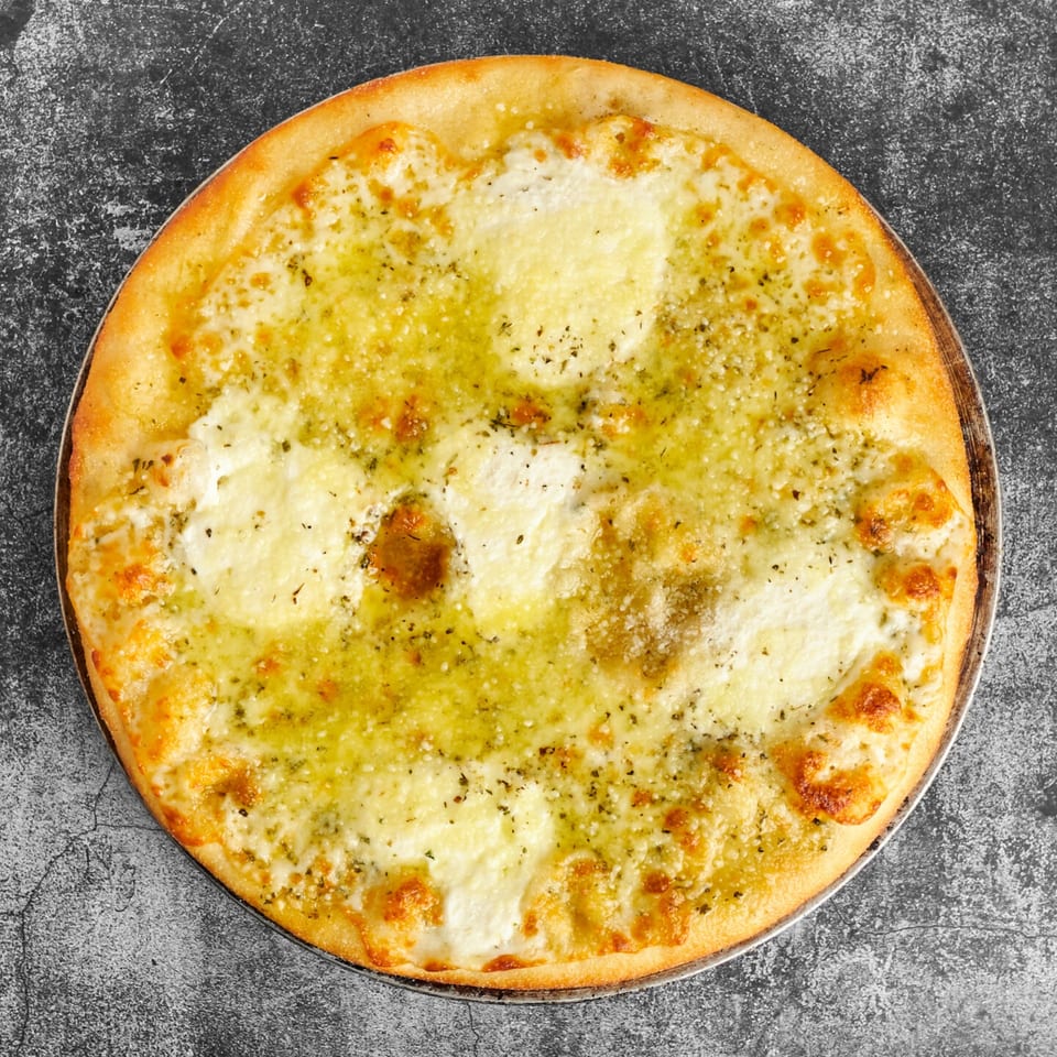 Trent's Pizzeria's garlic cheese pizza, topped with melted mozzarella, herbs, and olive oil.